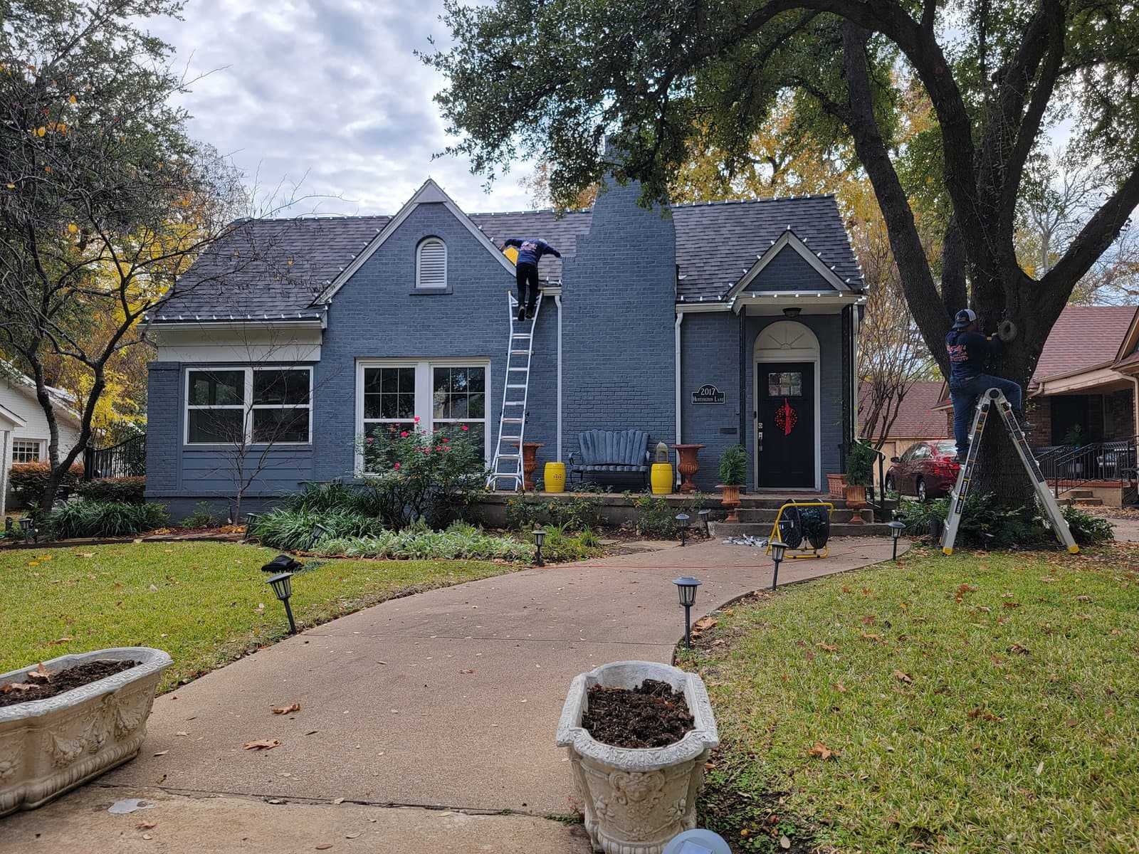 Frosty's crew installing holiday lights on a home